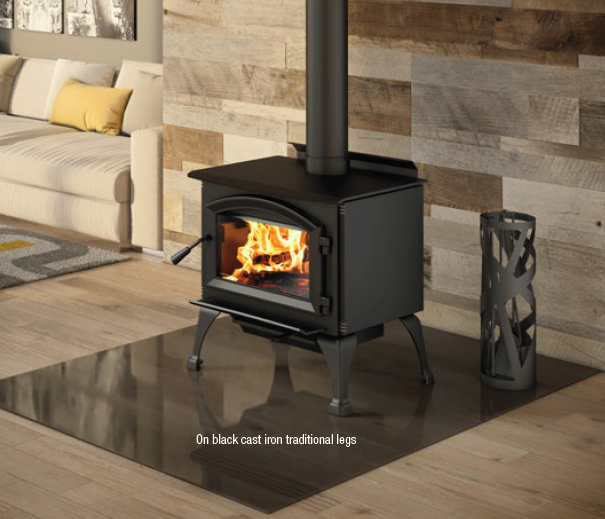 Black wood-burning stove with a visible fire in a modern living room on a hardwood floor.