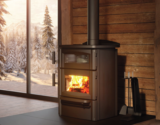 Wood-burning stove glowing in a rustic cabin beside a snowy window and stacked firewood.