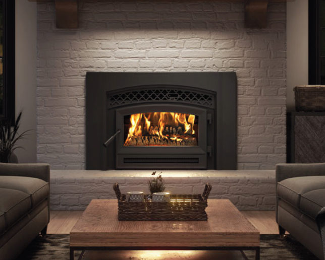 Cozy living room with a lit fireplace, brick surround, and a wooden coffee table with a basket centerpiece.
