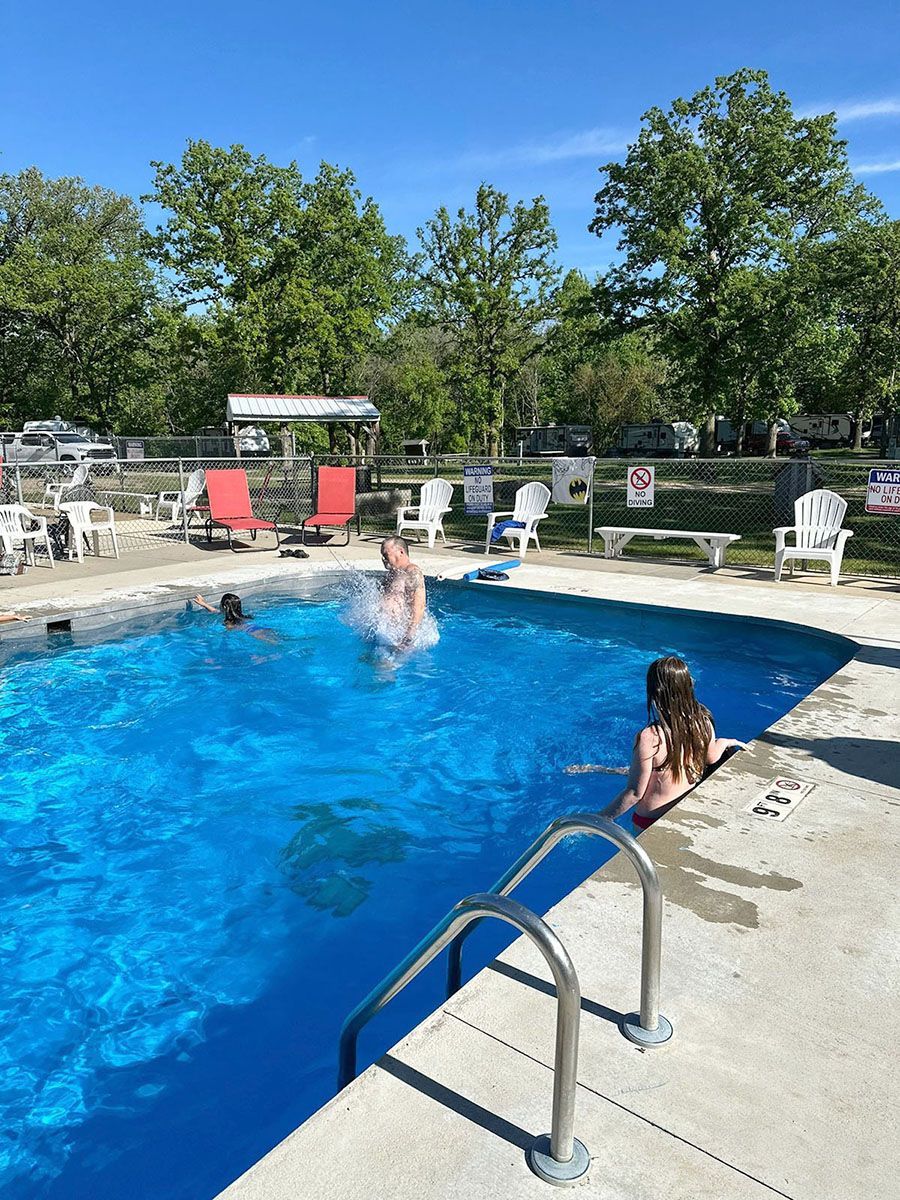 Pool with people swimming under a bright blue sky