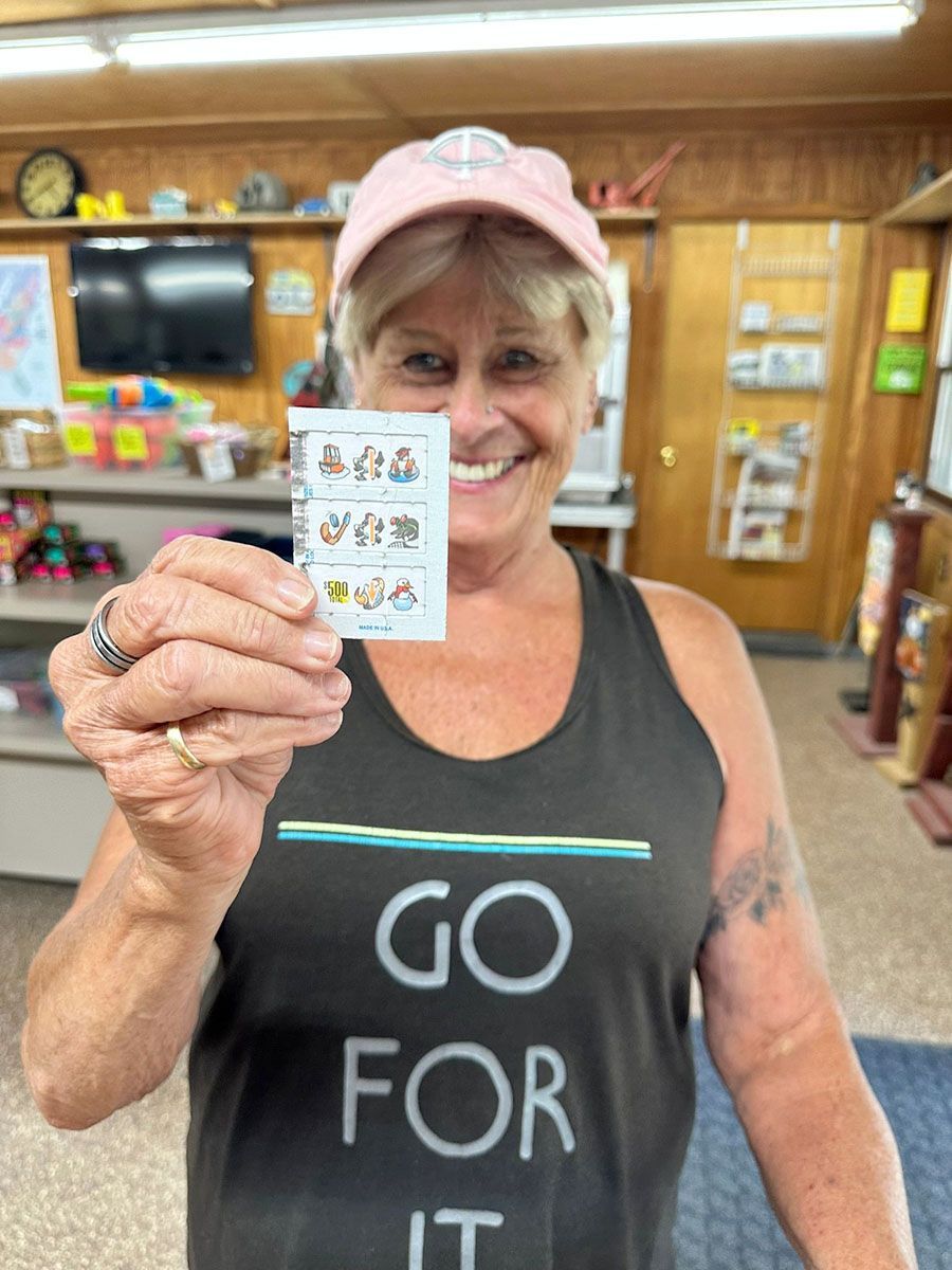Woman holding a small card with cartoon images inside a store