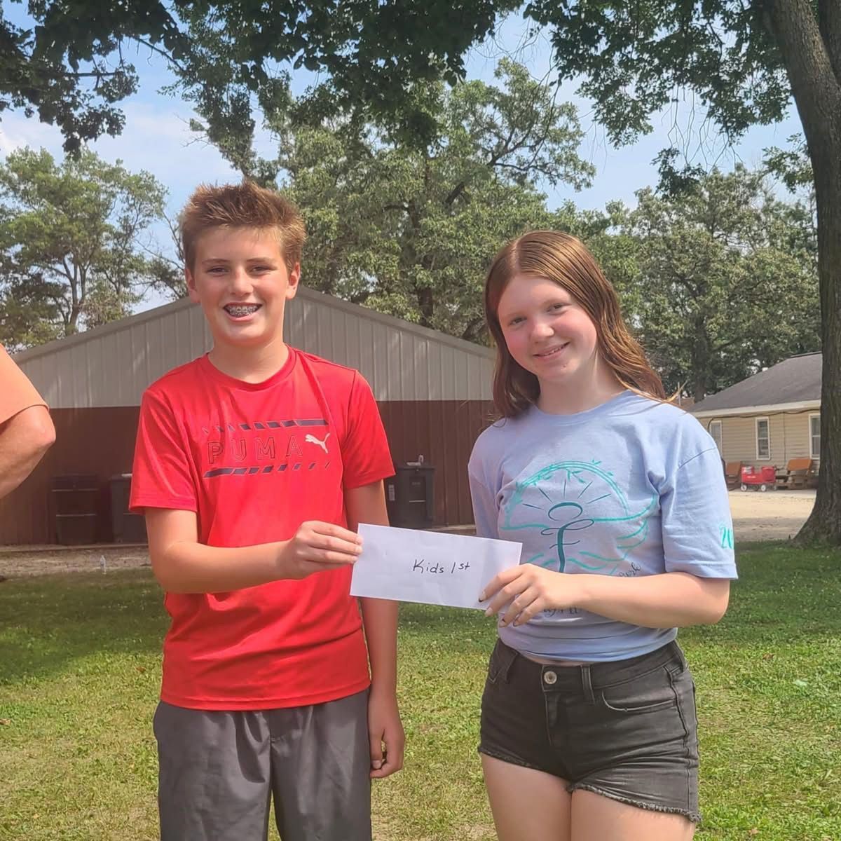 Two people holding a paper outside