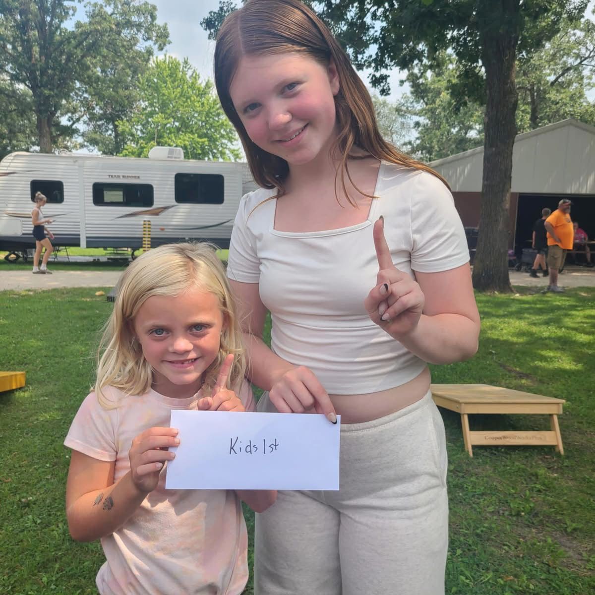 Two girls holding a white paper