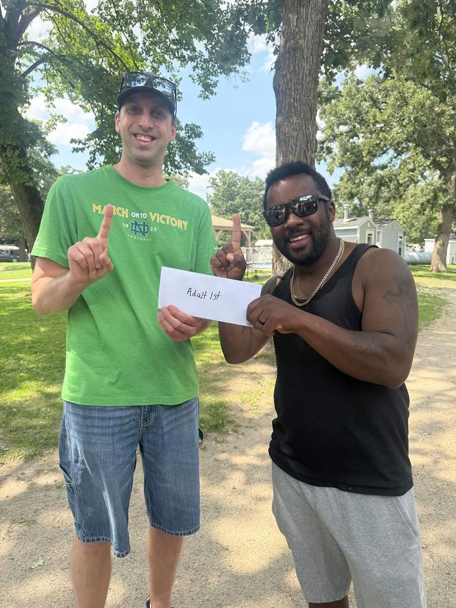 Two men outdoors holding a paper