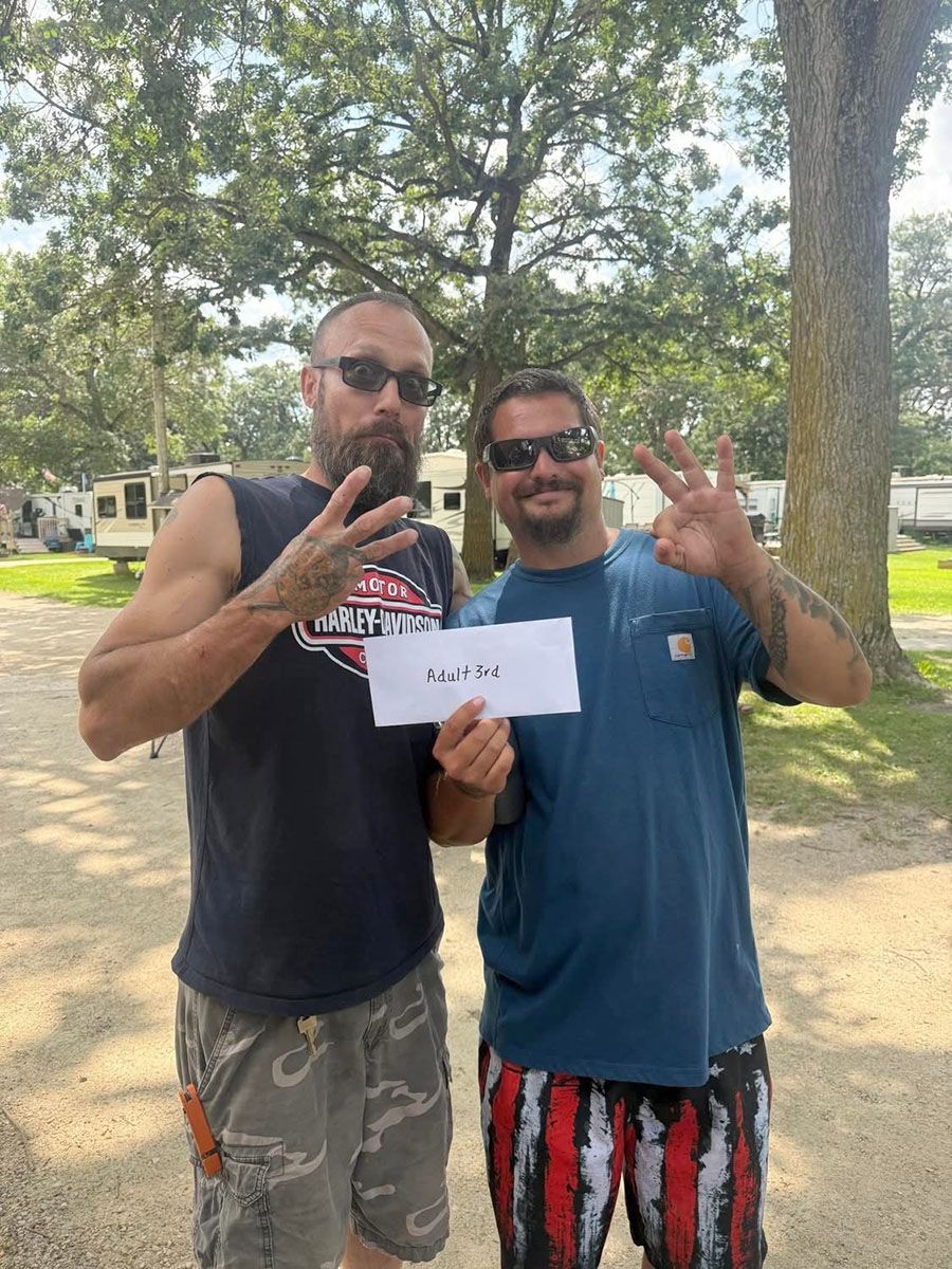 Two men smiling and holding a piece of paper