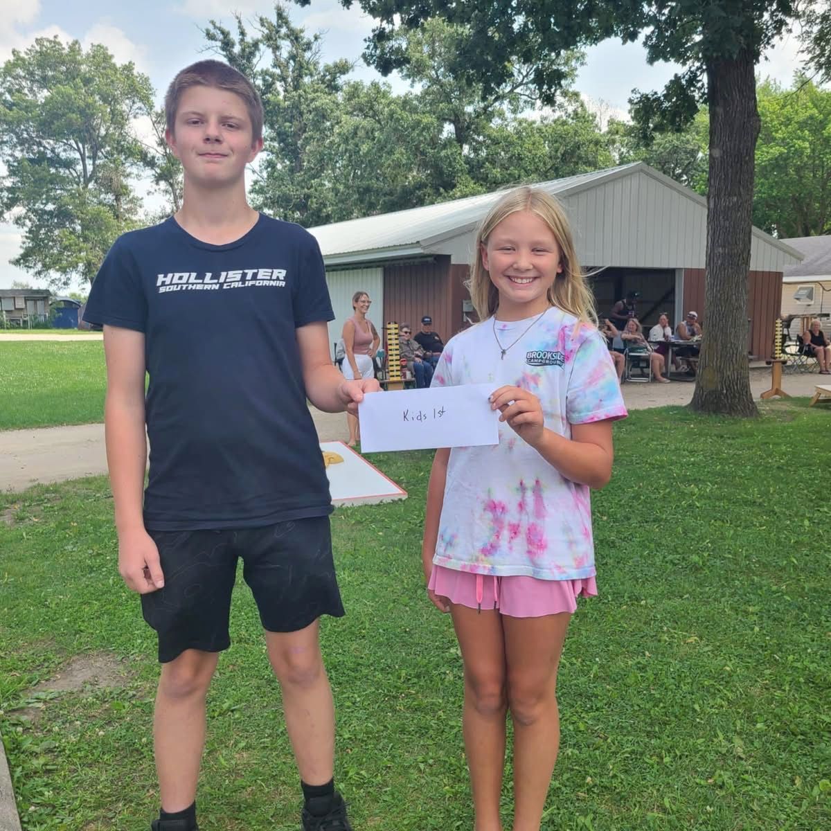 Two kids holding their prize outside, smiling
