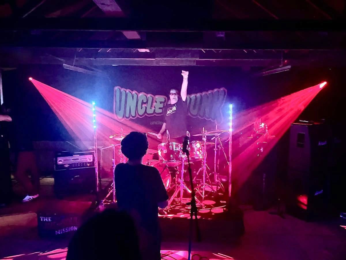 Drummer onstage with red spotlights