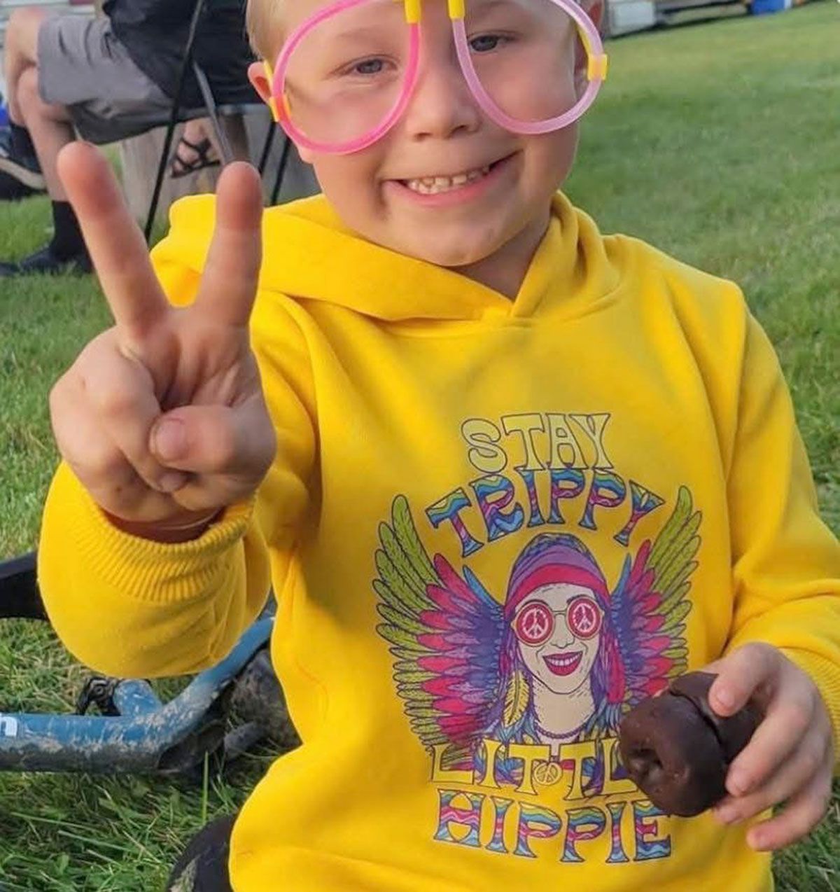 Boy in yellow hoodie holding a dark object