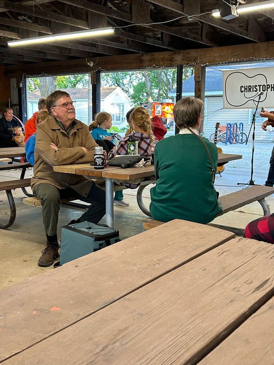 People at picnic tables under a shelter