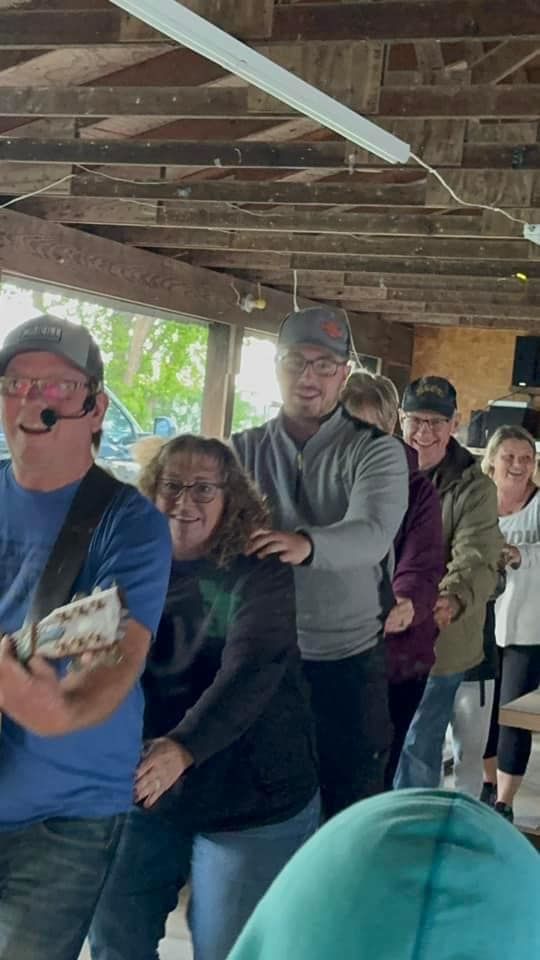 A man is playing a guitar in front of a group of people.