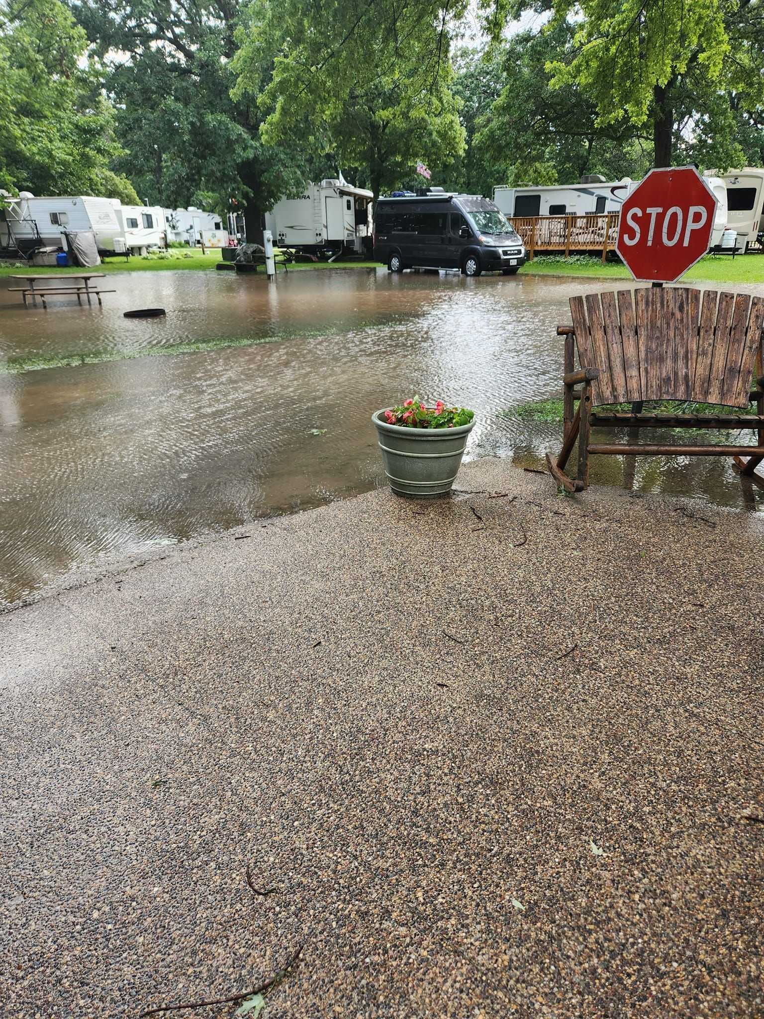 A stop sign is in the middle of a flooded parking lot.