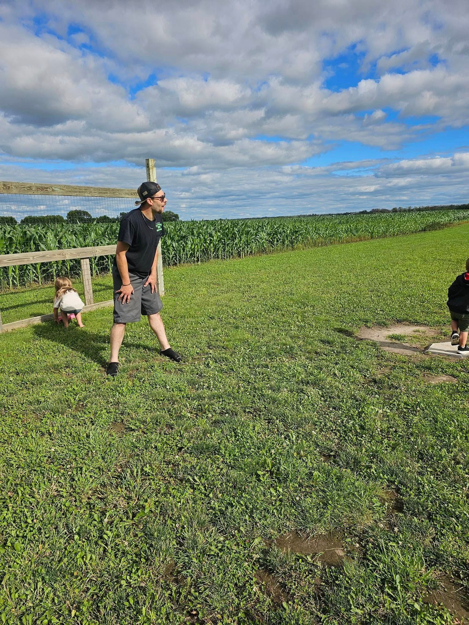 A man and a child are standing in a grassy field.