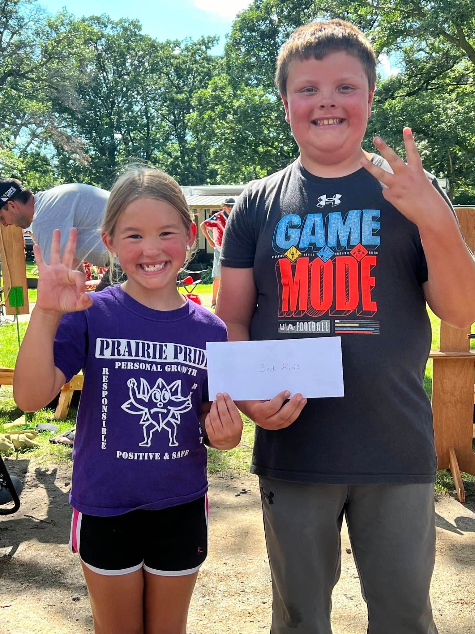 A boy and a girl are standing next to each other holding a paper.