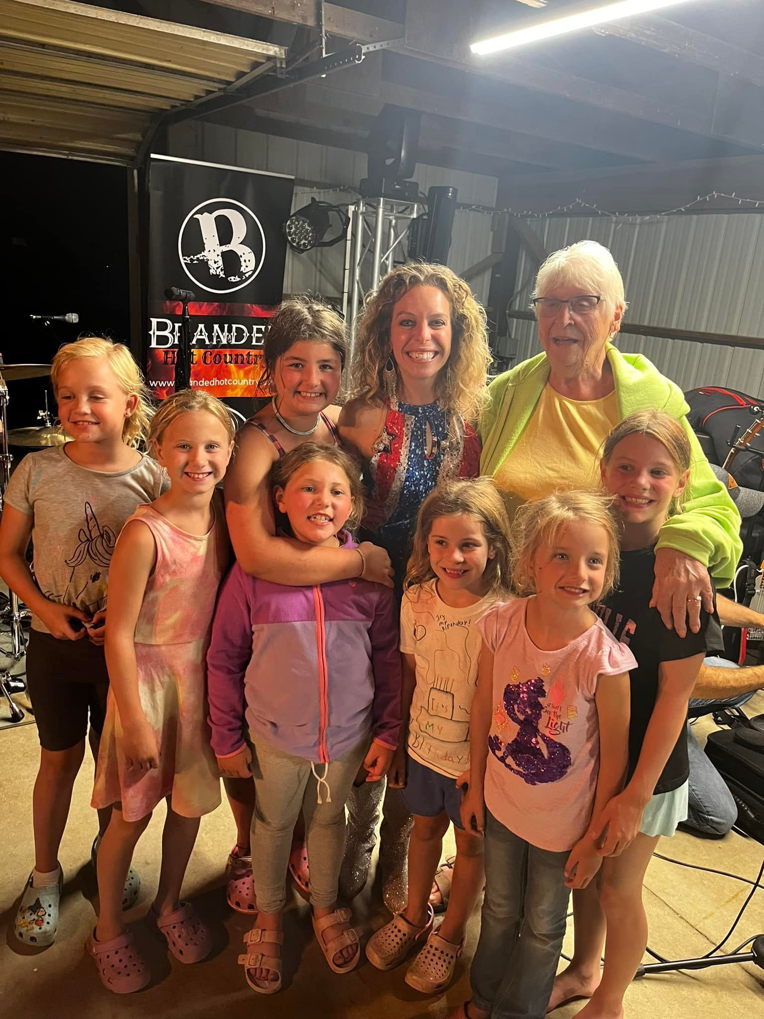 A group of young girls are posing for a picture with their grandmother.