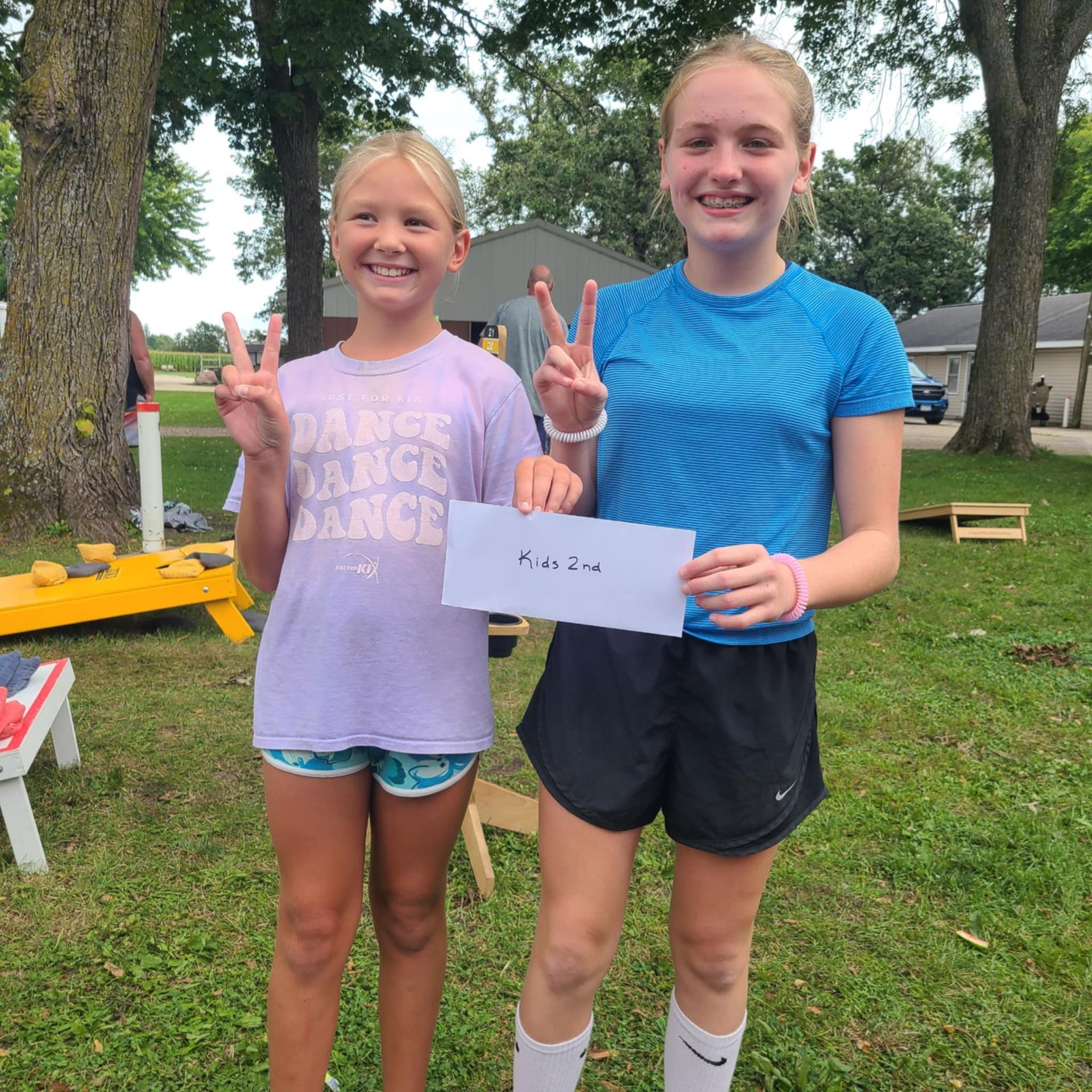 Two young girls are standing next to each other and one of them is wearing a shirt that says range dance.