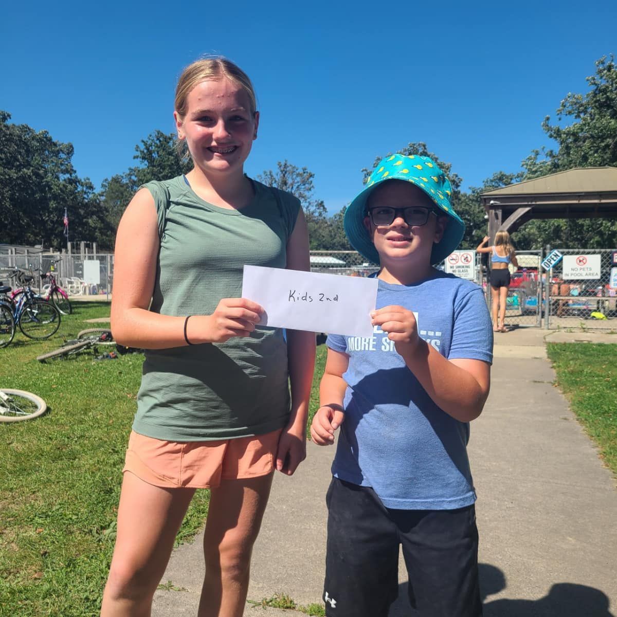 A boy and a girl holding a piece of paper.