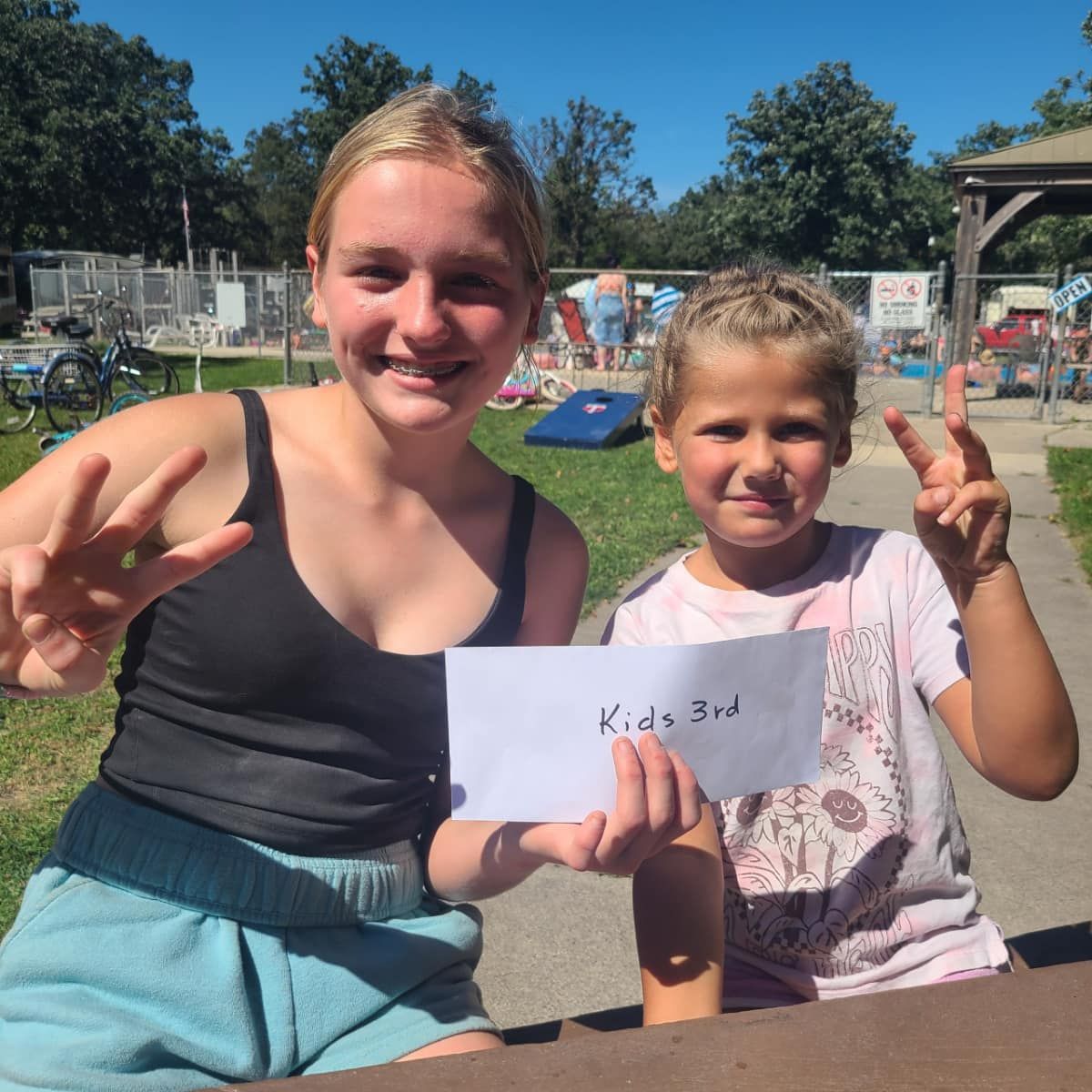 Two girls holding a sign.