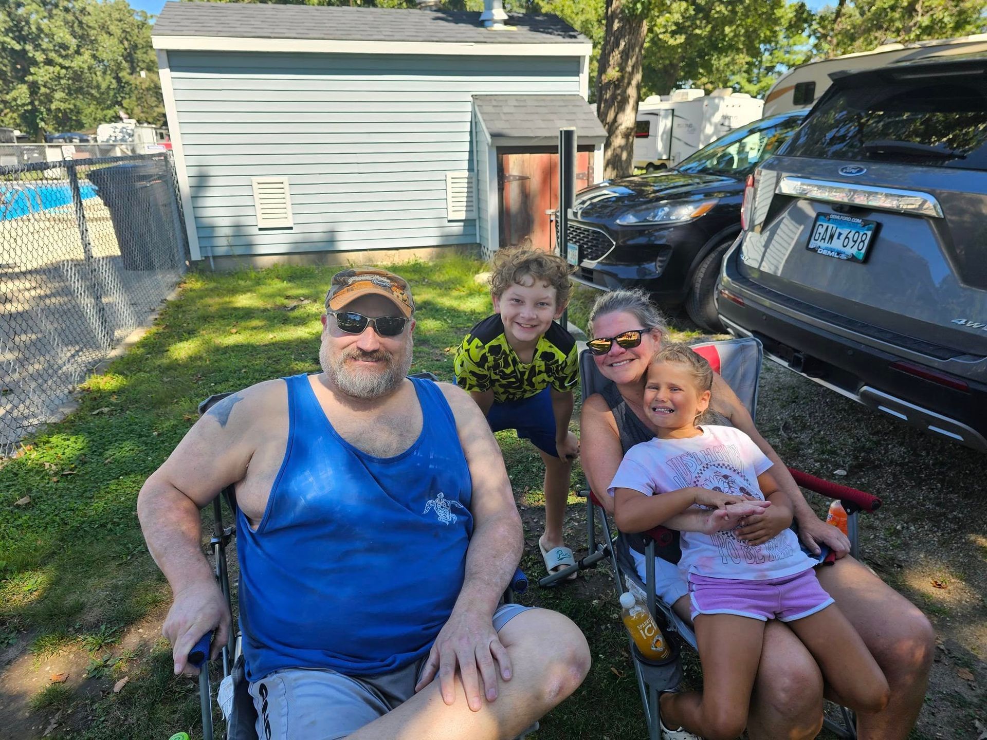 A man in a wheelchair is sitting next to a woman and two children.
