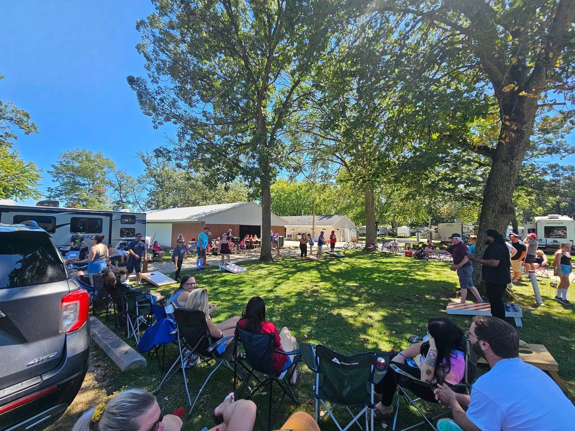 A group of people are sitting in chairs in a park.