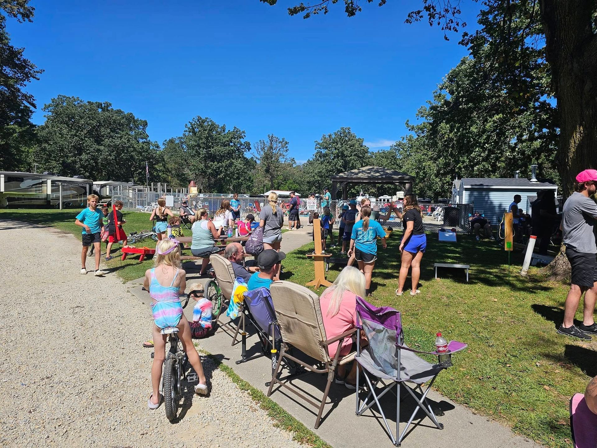 A group of people are sitting on benches in a park.
