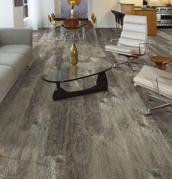 Wooden floor in a living room, with furniture like a sofa, chairs, and a coffee table.