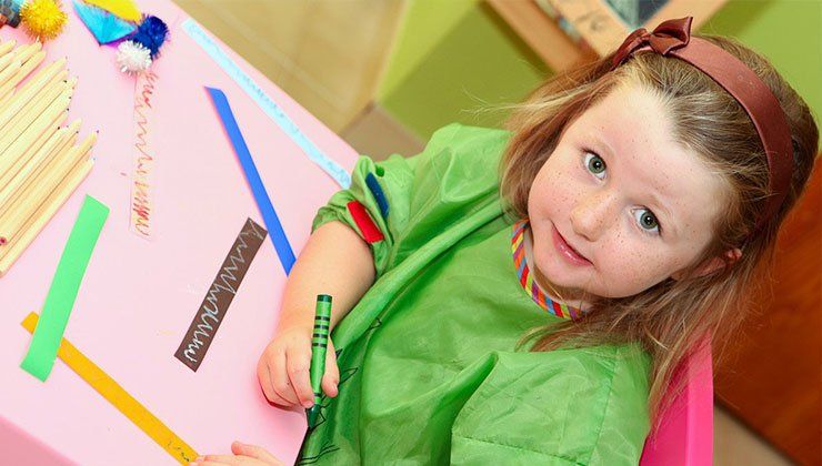 little girl holding a crayon