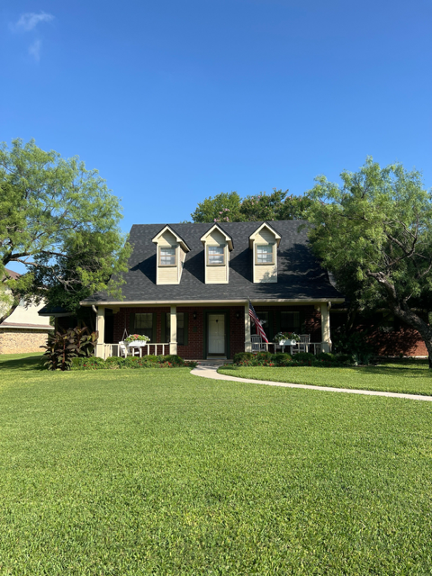 A large house with a lush green lawn in front of it.