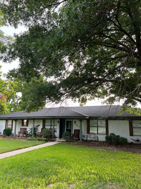 A house with a large tree in front of it