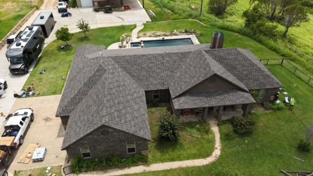 An aerial view of a house with a pool in the backyard