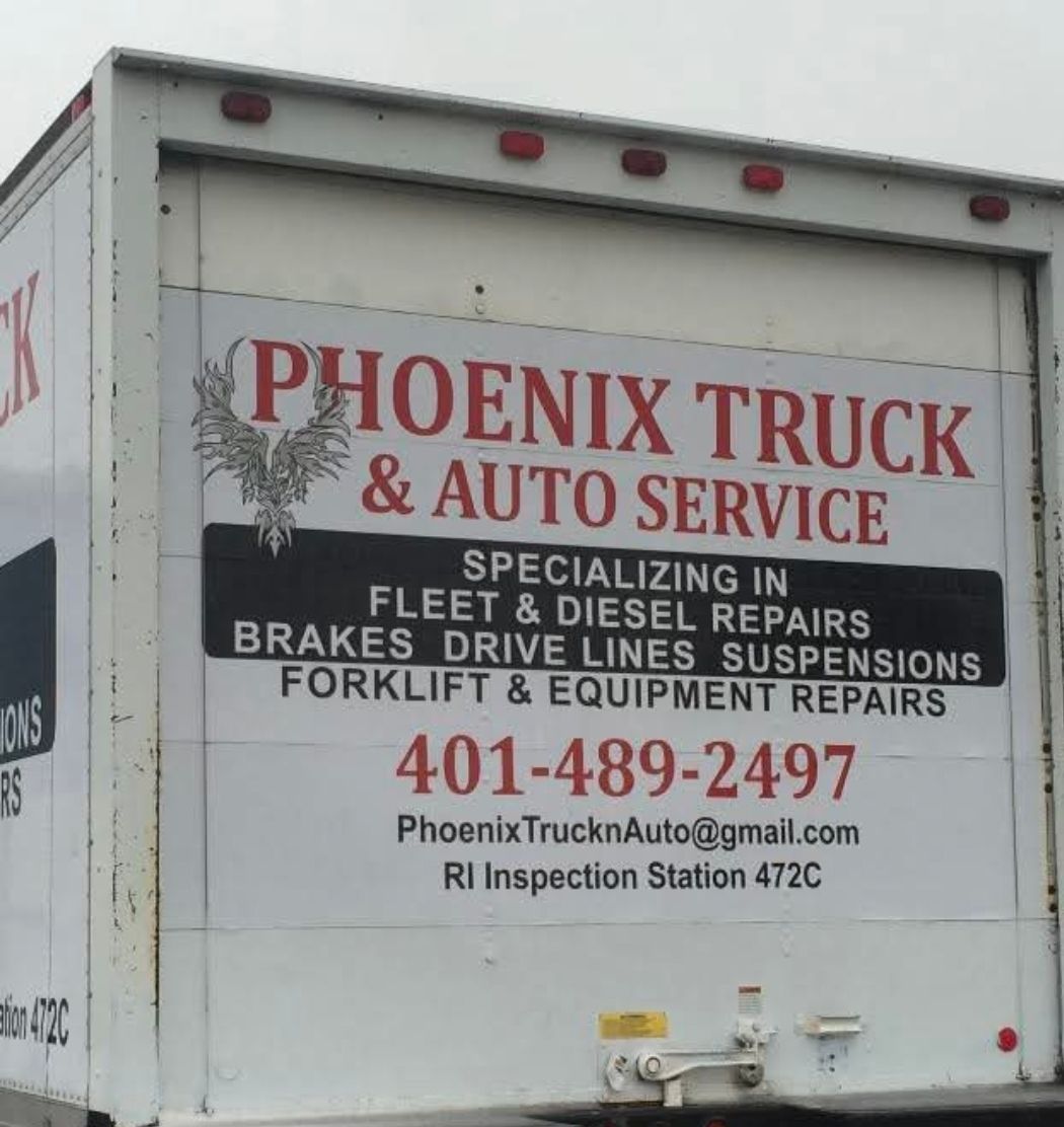Phoenix Truck & Auto Service sign on a white truck, listing repairs and phone number in red and black text