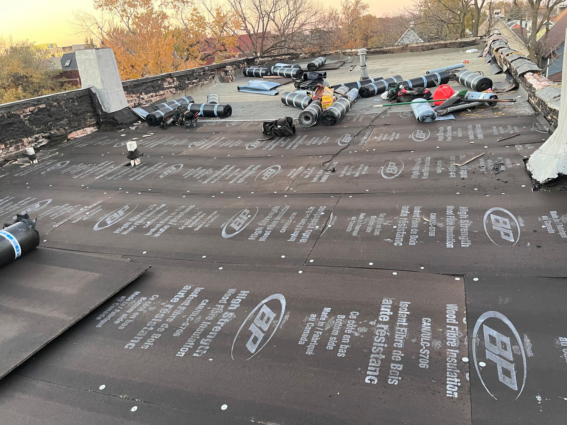 Rooftop with BP roofing material, equipment, and partially installed black membrane.