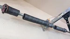 Torsion springs mounted on a metal shaft above a garage door.