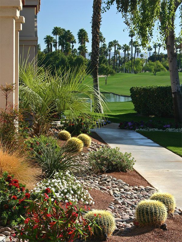 A walkway leading to a golf course with palm trees in the background