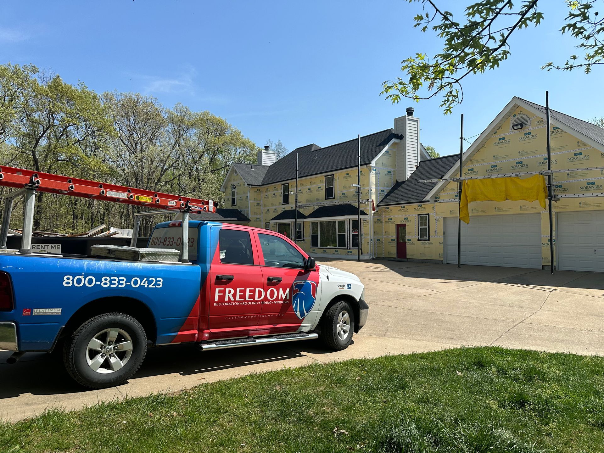 Freedoom service truck parked beside a yellow warehouse on a sunny day
