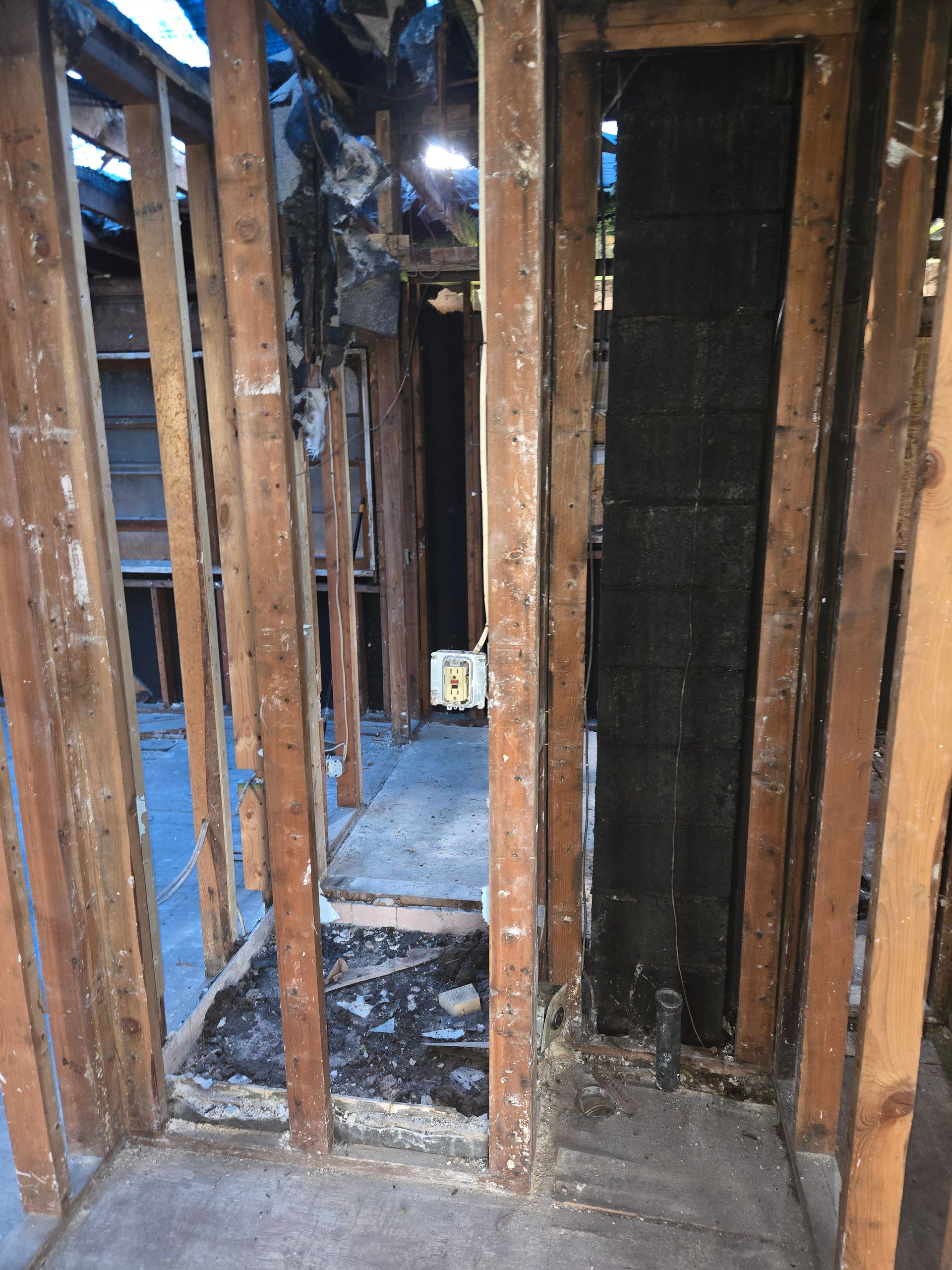 A room with wooden walls and a black door.