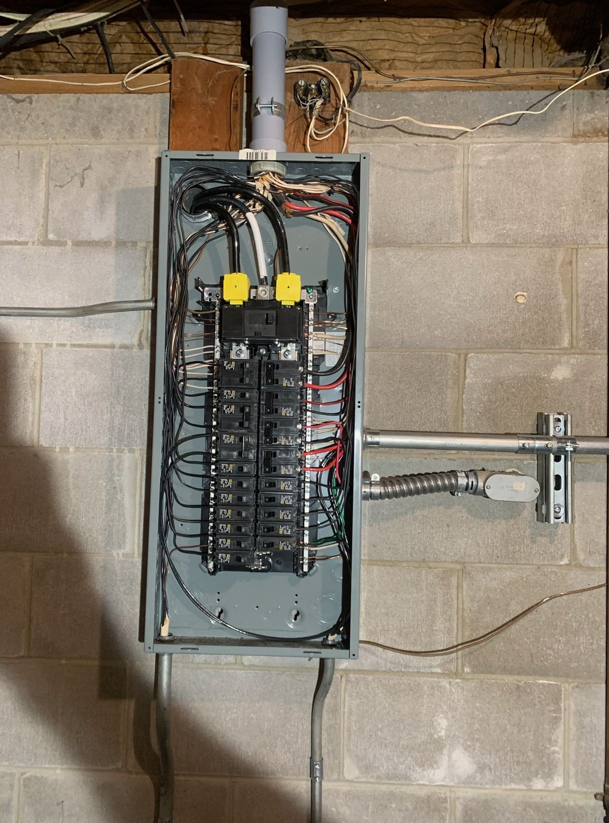 A electrical box is hanging on a brick wall.