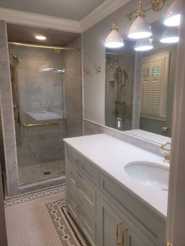 Elegant bathroom with glass shower, double vanity, mirrors, and pendant lights