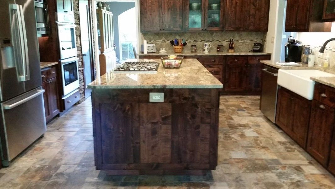Spacious kitchen with wood cabinets, a large stone island, and stainless steel appliances.