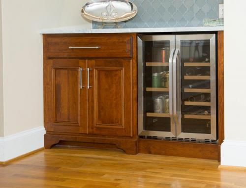 Built-in wet bar with wood cabinetry, countertop, and a wine refrigerator. The room has hardwood floors.