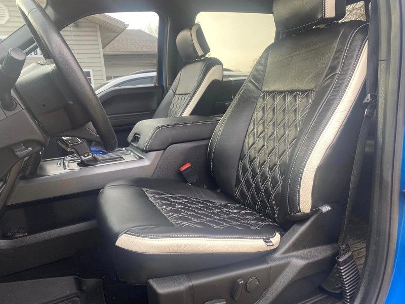 Blue Ford truck interior with black leather seats, diamond stitching, and white accents.