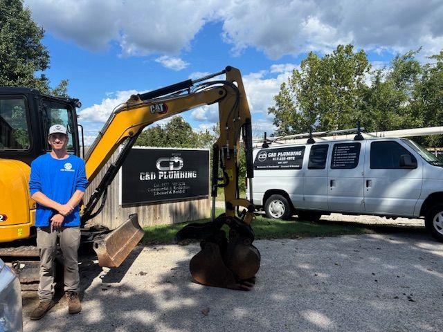Man stands by excavator and van