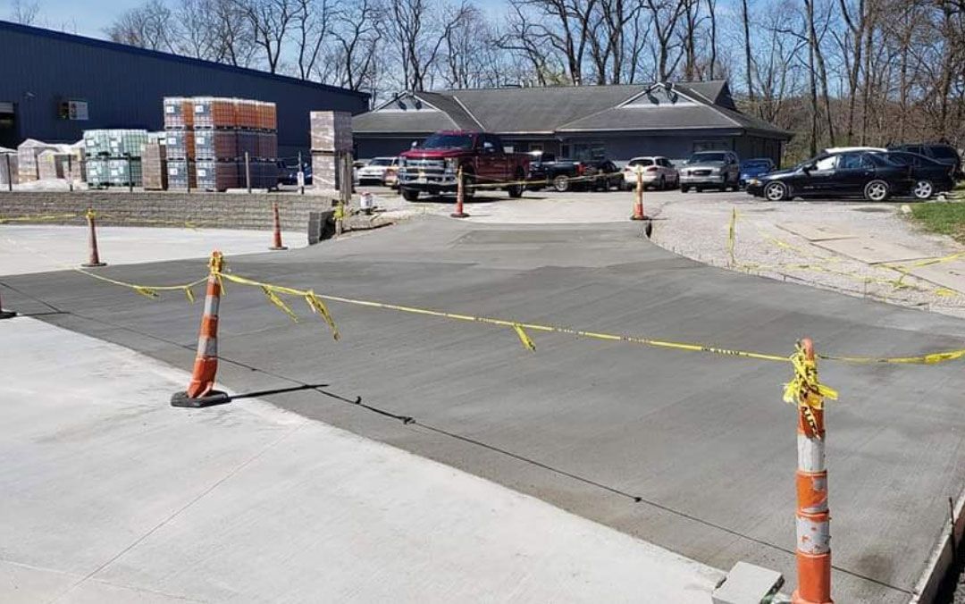 A concrete driveway is being built in front of a building.
