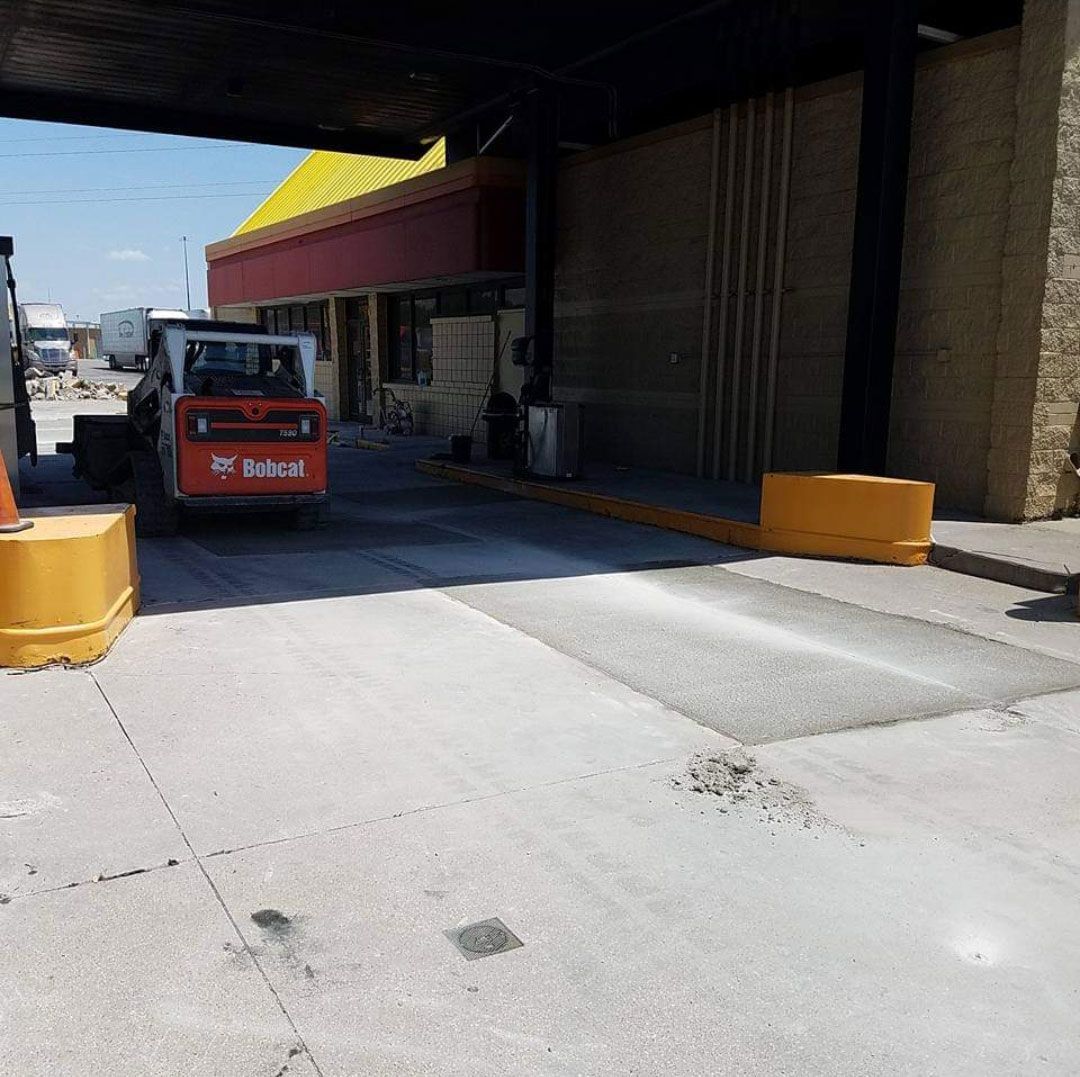 A bobcat forklift is parked in front of a building.