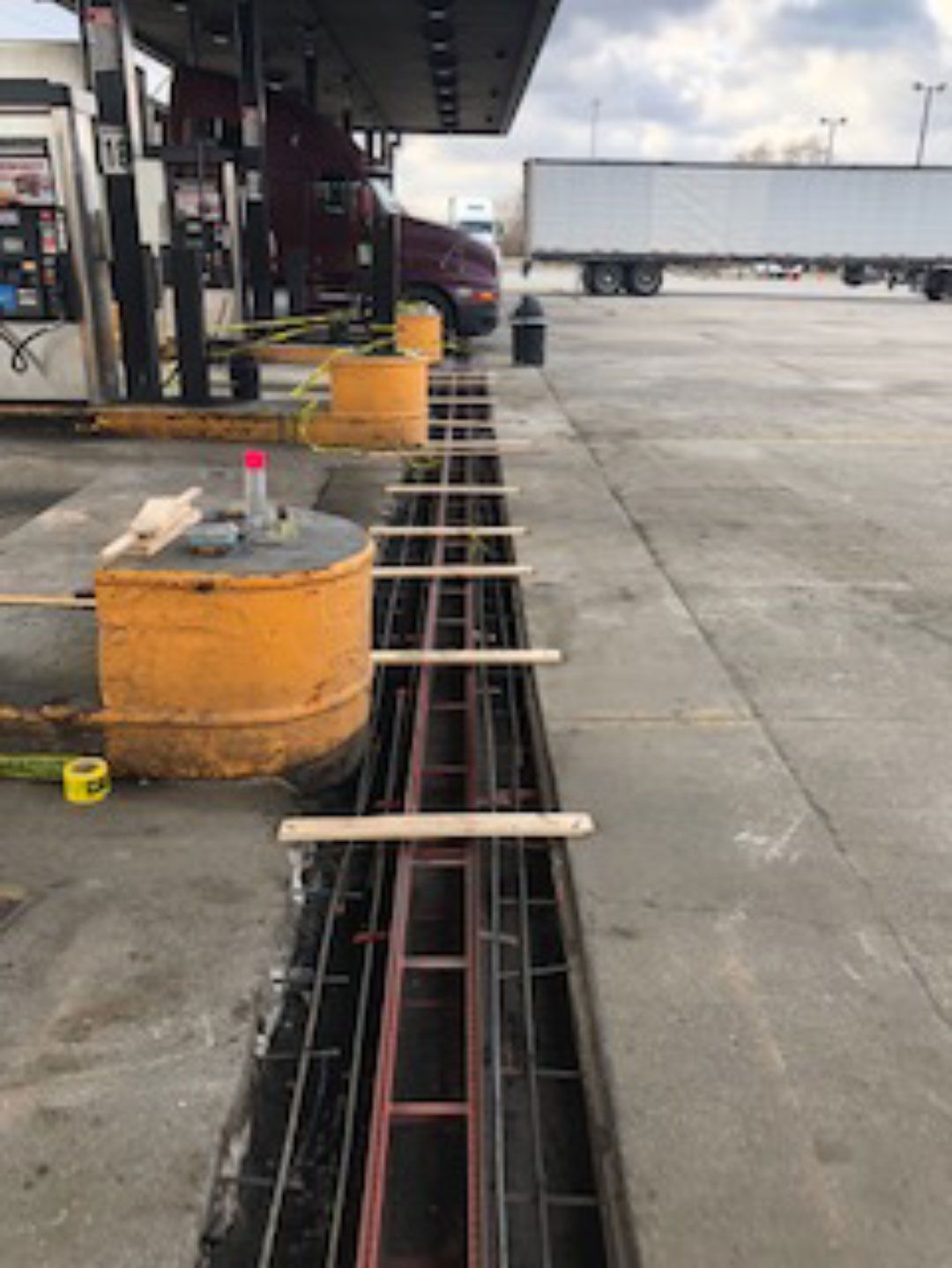A truck is parked in a parking lot next to a gas station.