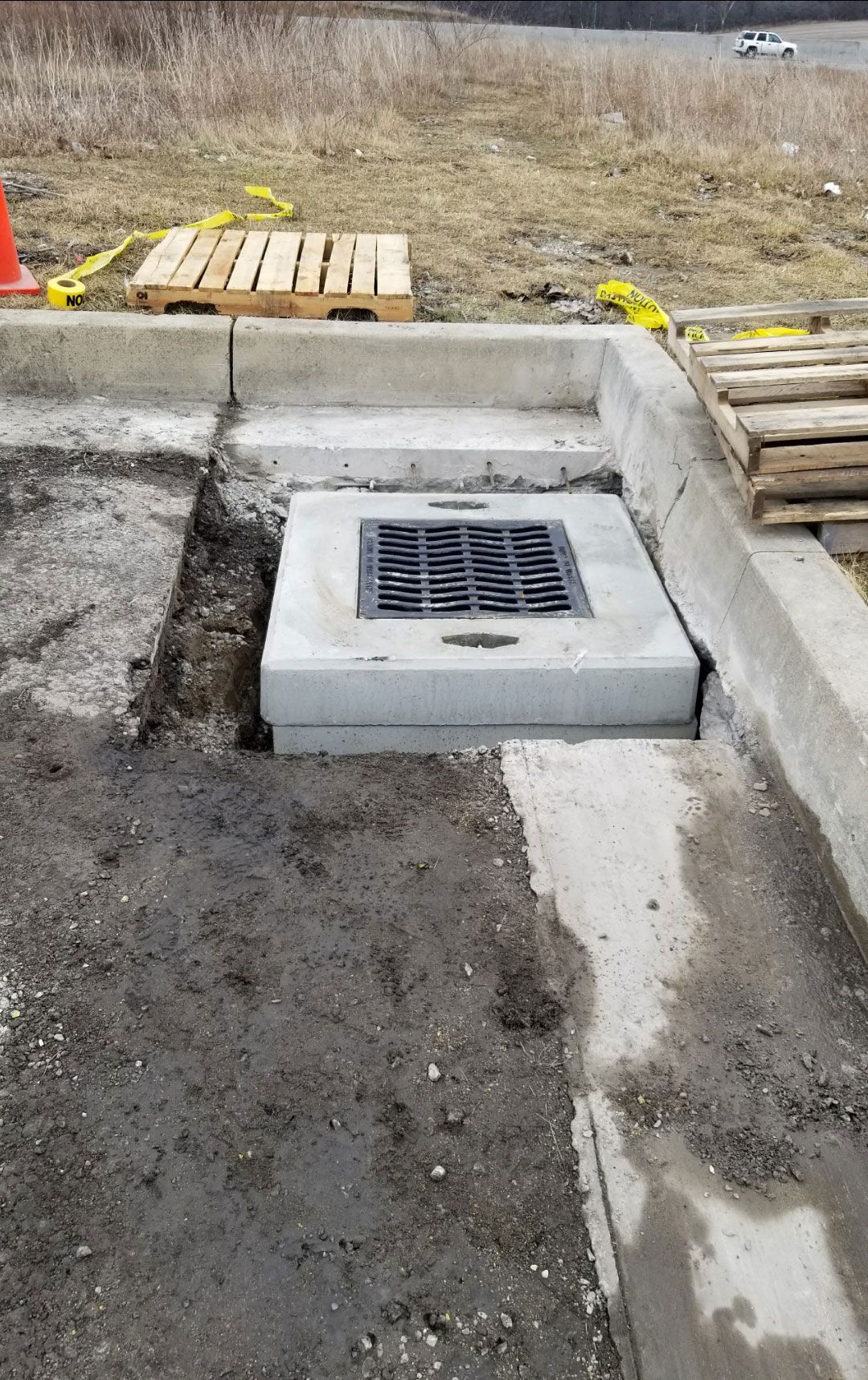 A drain is being installed on the side of a road.