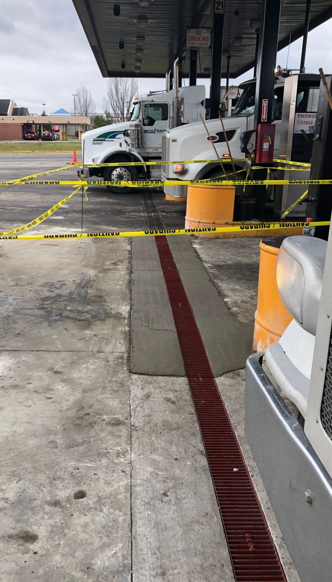 A truck is sitting in the parking lot of a gas station.