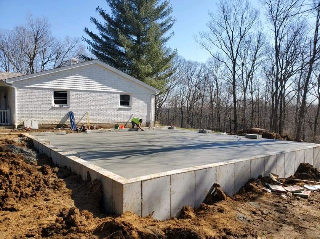 A concrete foundation is being built in front of a house.