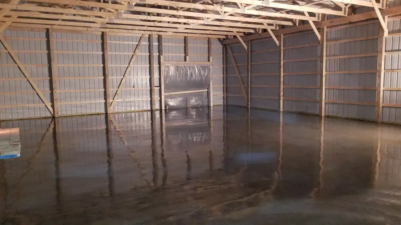 a large warehouse with a concrete slab floor and wooden walls