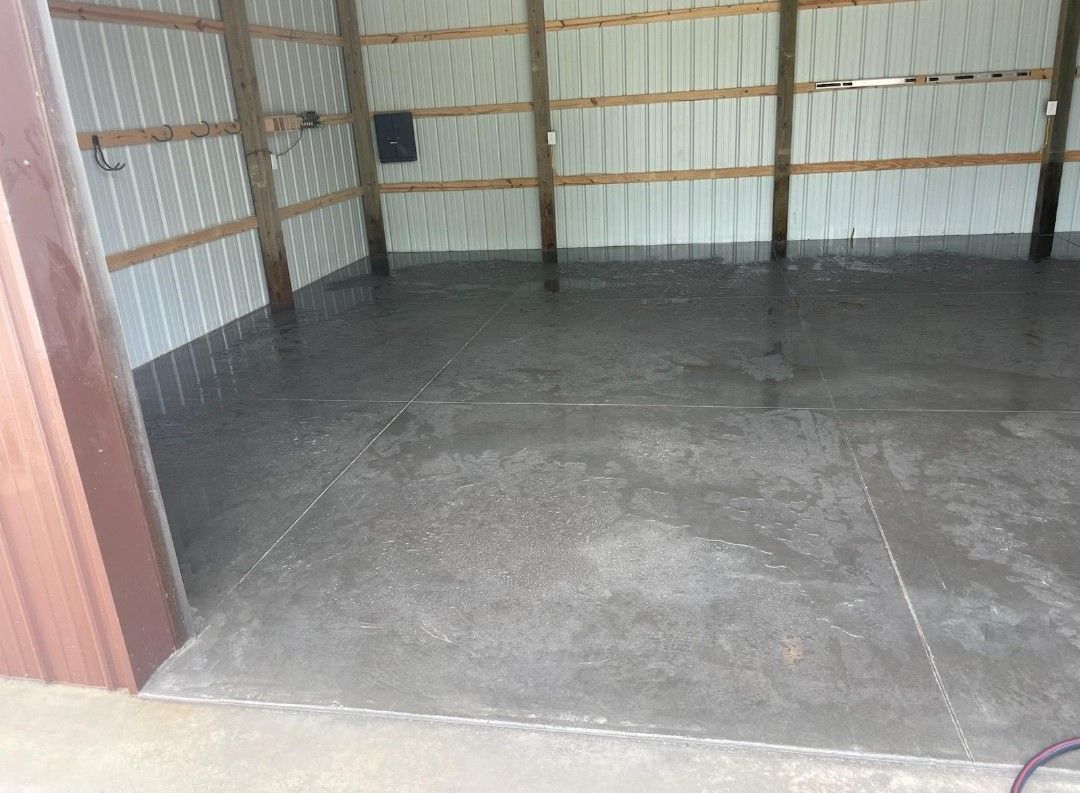 a garage with a concrete slab floor and wooden walls