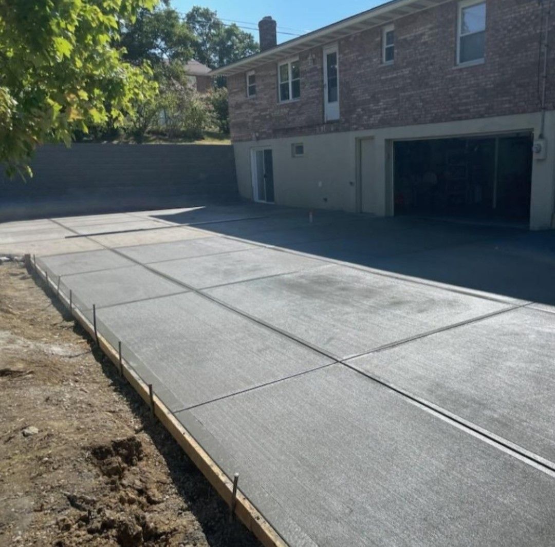 a brick house with a concrete driveway in front of it